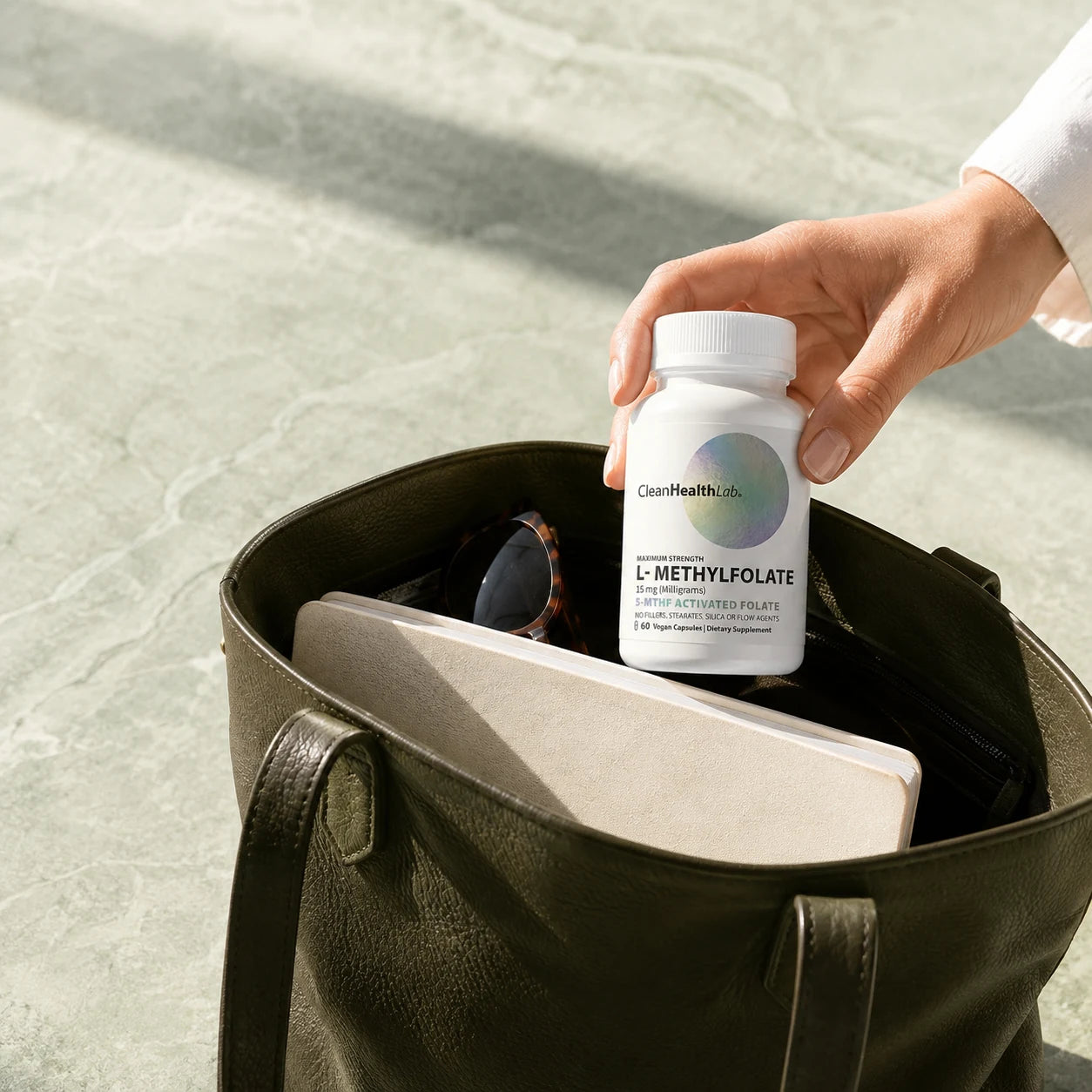 Hand placing Clean Health Lab L-Methylfolate into a bag